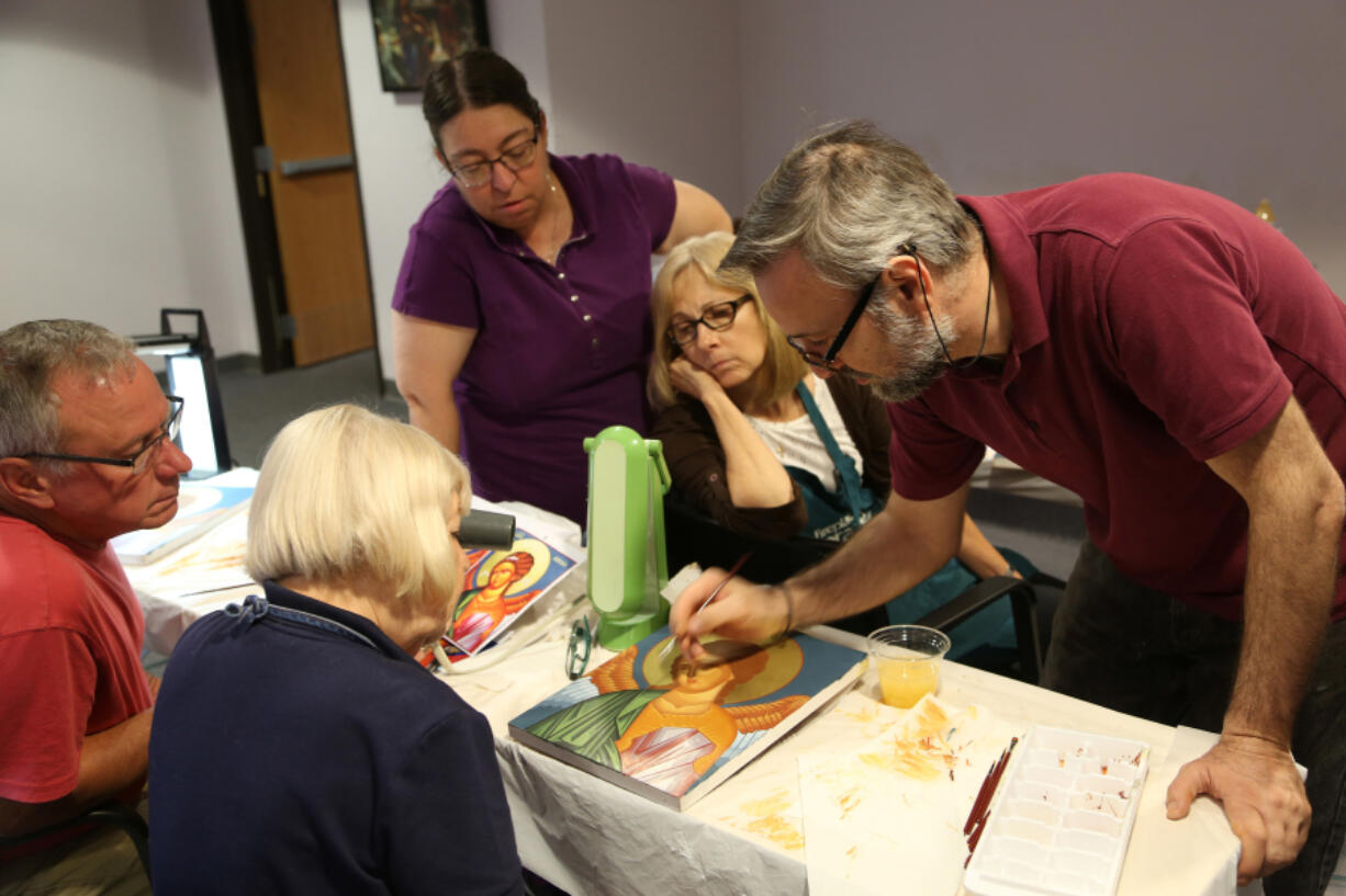 Theodoros Papadopoulos, a professional Orthodox iconographer from Greece, works with a small group July 14 at the Catholic Diocese’s Spiritual Life Center. Members of the class are creating icons of St. Michael.