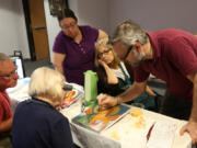 Theodoros Papadopoulos, a professional Orthodox iconographer from Greece, works with a small group July 14 at the Catholic Diocese’s Spiritual Life Center. Members of the class are creating icons of St. Michael.