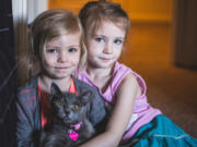 Molly and Elinor Egan hold their cat, Cleo.