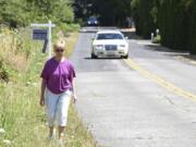 Vi Towne walks along Southeast Evergreen Highway near her home where there are no sidewalks for pedestrians. Towne usually drives a mile to the nearest area with a sidewalk for her walks. A collaboration between area residents and the city of Vancouver is working to provide a safe walking and cycling access along the former highway.