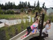 Camas residents Milan Turnbull, 6, swings onto the slide next to Halle Iverson, 6, as Marina Carlson, 6, waits for her turn behind them at Cooper’s View Park in Camas. A recent survey found residents think the city should improve parks and streets.