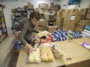 Volunteer Cindy Johnson sorts bread and other items in a crowded supply room at Clark County Adventist Community Services Monday morning.