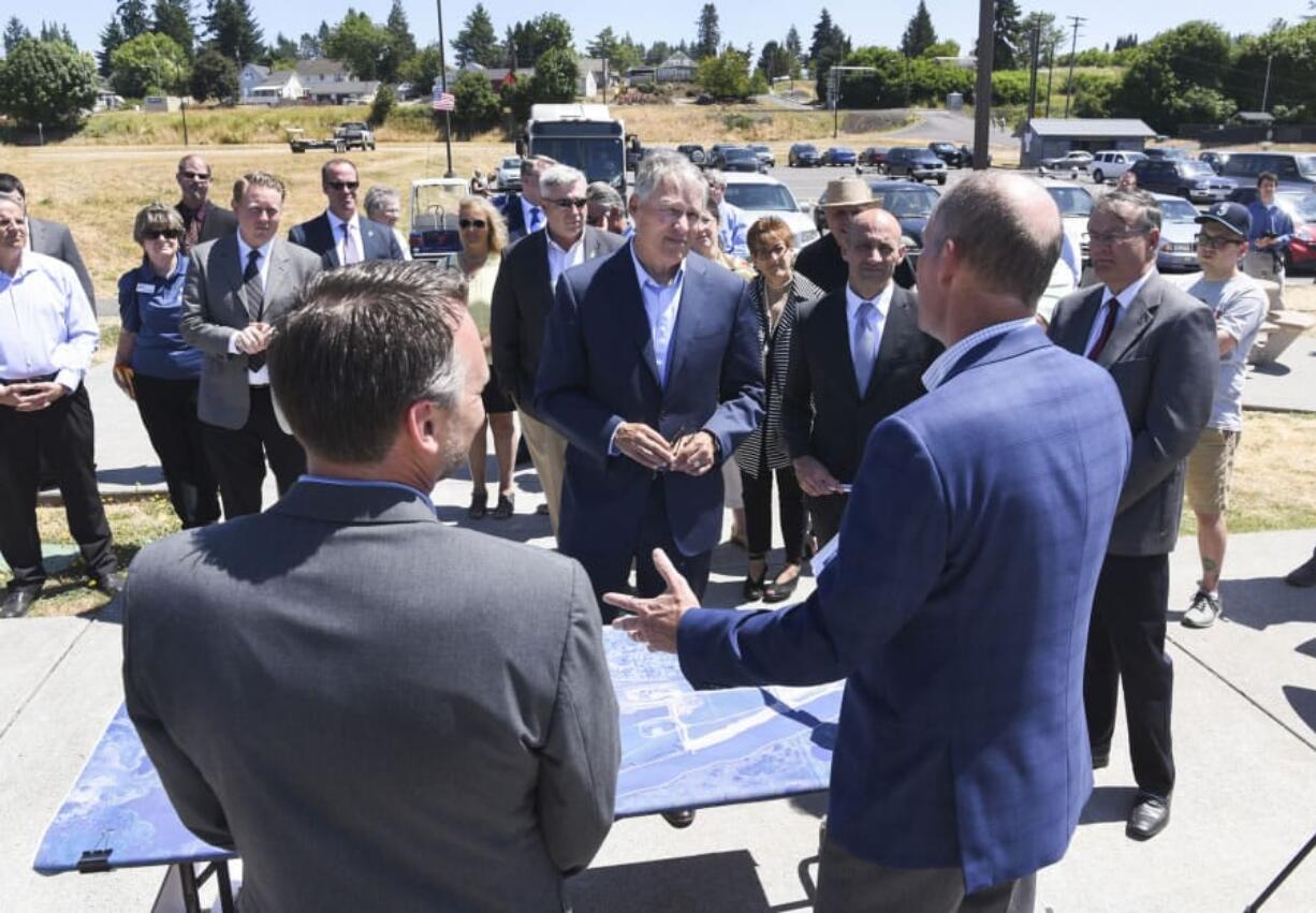 Gov. Jay Inslee, center, listens to Port of Ridgefield CEO Brent Grening, right, discuss the city, port and state joint effort to clean up the Ridgefield waterfront, which is ready for development after a $90 million clean-up effort. Inslee was in Ridgefield on Tuesday to tour the city.