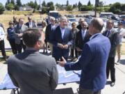 Gov. Jay Inslee, center, listens to Port of Ridgefield CEO Brent Grening, right, discuss the city, port and state joint effort to clean up the Ridgefield waterfront, which is ready for development after a $90 million clean-up effort. Inslee was in Ridgefield on Tuesday to tour the city.