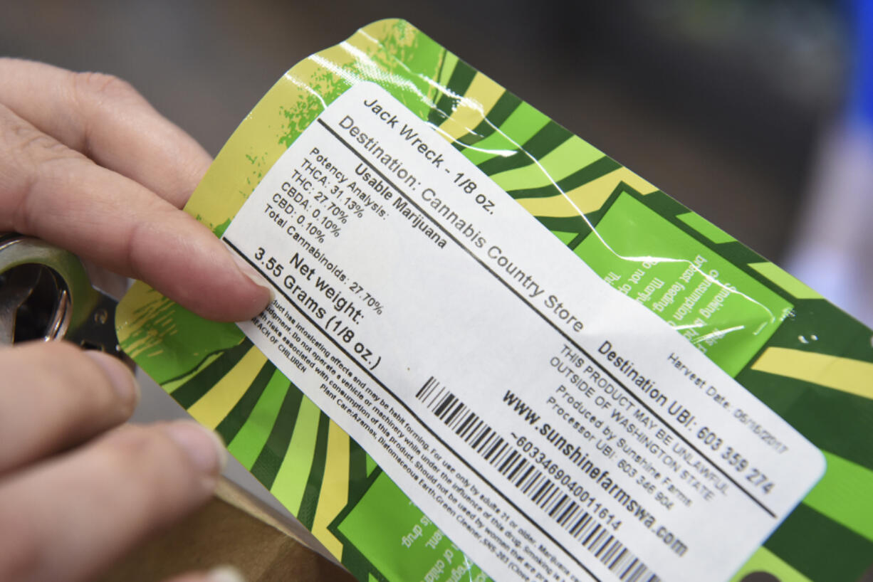 Amy Kennedy-Palma reads the packaging for Jack Wreck, a sativa strain of marijuana, at Cannabis Country Store in Battle Ground. Kennedy-Palma uses marijuana to manager her anxiety and sleep issues.