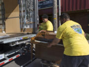 Big Al’s Specialty Movers crew George Aiono, left, and San Fernando Vaovasa take away the last piano.