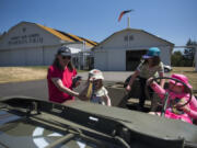 Susan Wood of Damascus, Ore., left, helps her daughter Emilia Wood, 5, into a 1945 Willys Jeep with her sister Elora Wood, 7, and their friend Claire Zielke of Portland, 7, at the 113th Cavalry Living History Group encampment just west of Pearson Air Museum on Friday afternoon. The encampmnt continues toay from 9 a.m. to 5 p.m.