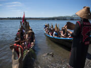 Members of the Cowlitz Canoe Family head for their landing spot on the Columbia River beach Tuesday, after the first leg of their trip to Campbell River, B.C.