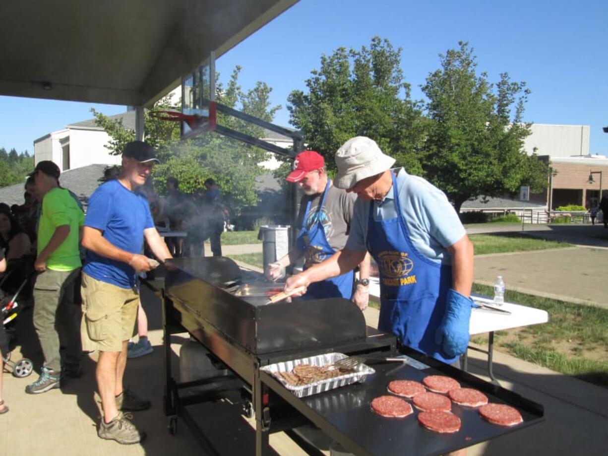 Five Corners: Cascade Park Kiwanis members, from left, Steve Savage, Clyde Holloway and John Neumann grill burgers and hot dogs for the annual foster children’s barbecue, hosted by the Kiwanis and Department of Social and Health Services.