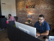 Josh McKinney, chief technology officer at Edge Networks, left, and President Mark Tishenko work at the downtown Vancouver office. The company has seen revenues rise 20 percent since offering an on-call cybersecurity service.