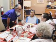 CDM Services Caregiver, George Spooner, left, asks clients what they would like to drink for lunch at CDM Services, an adult care facility in Vancouver, Wednesday June 28, 2017.