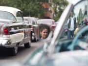 Makila Schuck peers at vintage cars on Main Street in downtown Vancouver in 2016.