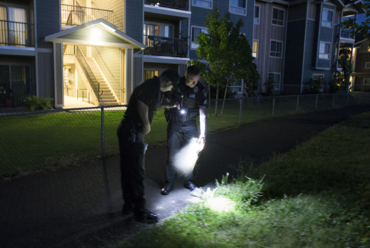 Vancouver Deputy Fire Marshal Cristian Ganea (left) and Ryan Wilson, a patrol officer with Metro Watch, investigate following a report of illegal fireworks Sunday. They found a bag full of sawdust that might have been used to store fireworks. (Randy L.