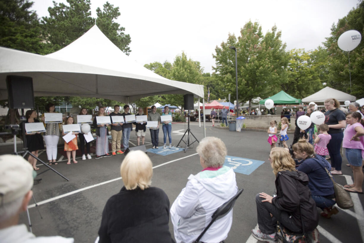 A previous crop of student poets displays poem placards that went up on C-Tran buses as part of the local “Poetry Moves” program. Another group of student poets will read original bus-bound works at 11:30 a.m. Saturday at the Vancouver Farmers Market music stage.