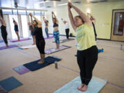 Kelli Rowe of Hazel Dell stretches into a pose during a class July 12 at Bikram Yoga Hazel Dell. After being injured in a car crash three years ago, Rowe found Bikram yoga as a way to heal. She has attended two classes a day since early May and intends on sticking with that schedule as long as she can.