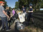 Woodland residents Ethan Blackwelder, 14, left, Vanessa Franke, 16, Erin Madsen, 14, Aaron Blackwelder and Aidan Blackwelder, 12, collect trash at Fort Vancouver National Historic Site the morning after the Independence Day celebration.