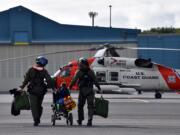 Coast Guard Petty Officer 1st Class Keola Marfil, honorary Petty Officer 3rd Class Andrew Bishop and Petty Officer 2nd Class Cody Dickey walk to an MH-60 Jayhawk helicopter during a search and rescue drill at Coast Guard Air Station Kodiak, Alaska, on July 8. Fulfilling Bishop's wish to be a rescue swimmer, they hoisted a hiker and simulated CPR while transporting him to the air station. (U.S. Coast Guard photo by Lt. Cmdr.