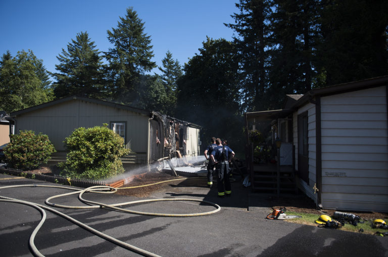 Officials work the scene of a fire that damaged two mobile homes at Green Mountains Mobile Ranch on Tuesday afternoon.