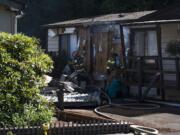 Officials work the scene of a fire in two mobile homes at Green Mountains Mobile Ranch on Tuesday afternoon.