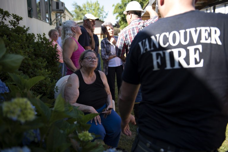 Resident Deborah Holtertalks with an official after her home and the home next door caught fire at Green Mountains Mobile Ranch on Tuesday afternoon.