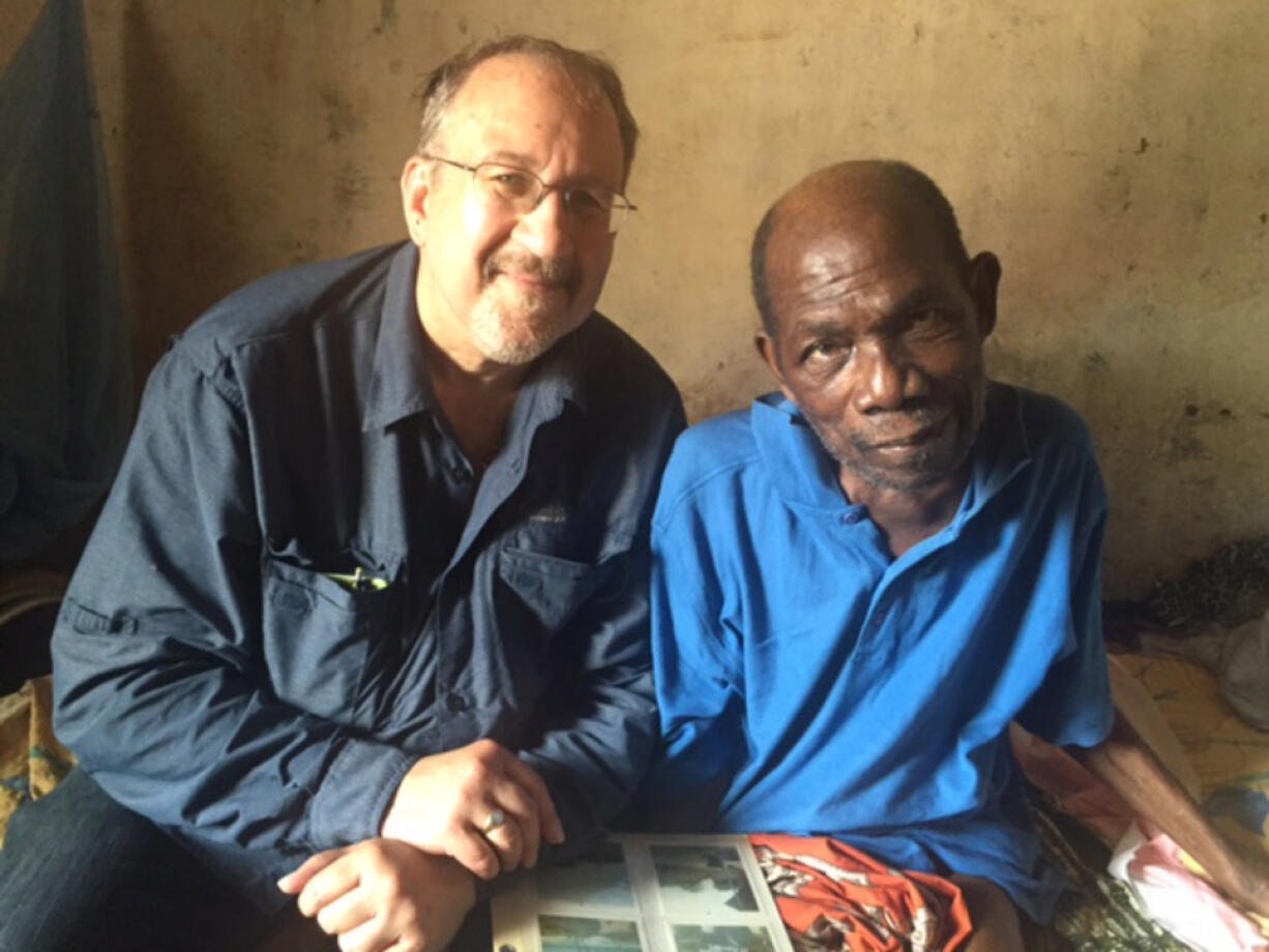 Photo by Brenda Lee Paul Ventura, left, and his old friend Emmanuel looking over photo albums in Ghana last month.