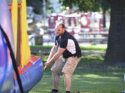 Ian Manheimer, owner of Bounce-N-Battle Inflatable Party Rentals in Vancouver, secures a bounce house before an event at Marshall Recreation Center.