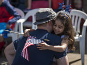 Jewel Anderson, 5, embraces her father David, both of Ridgefield, as they wait for the Wild, Wild, West 4th of July parade to begin in downtown Ridgefield on Tuesday afternoon. The small community has been celebrating Independence Day for more than 100 years. Organizer Sandy Schill touted the event’s family-friendly atmosphere, which encourages families to return to the parade year after year.