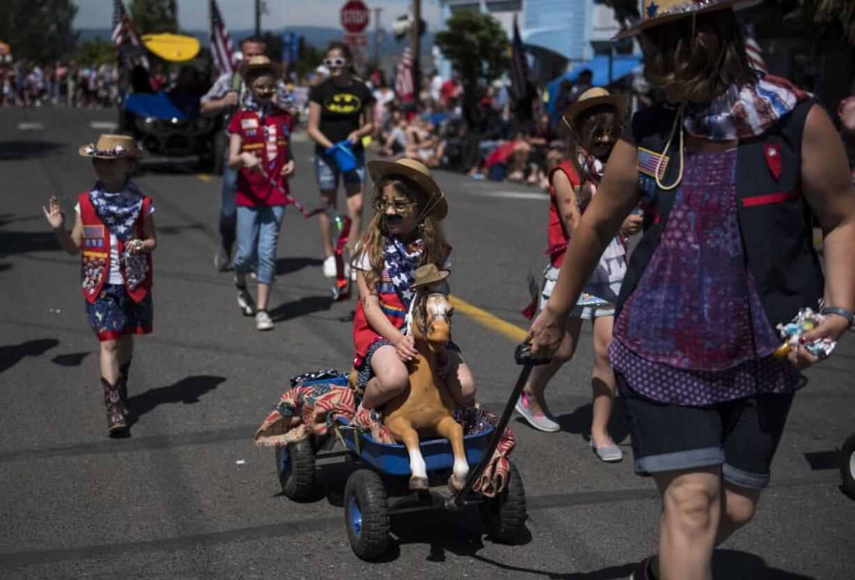 Lilly Cohen of La Center, 9, sports cowgirl attire as she rides along with the Frontier Troop 297 during the Wild, Wild, West themed Fourth of July parade in downtown Ridgefield on Tuesday afternoon. Thousands attended the time-honored traditional parade, which winds through downtown Ridgefield.