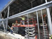 Construction workers with Harlen’s Drywall of Vancouver install galvanized metal framing at a new medical building under construction in Salmon Creek in 2013. The project has benefited from Clark County’s fee holiday program, which it now is seeking to wind down after a vote to repeal it.