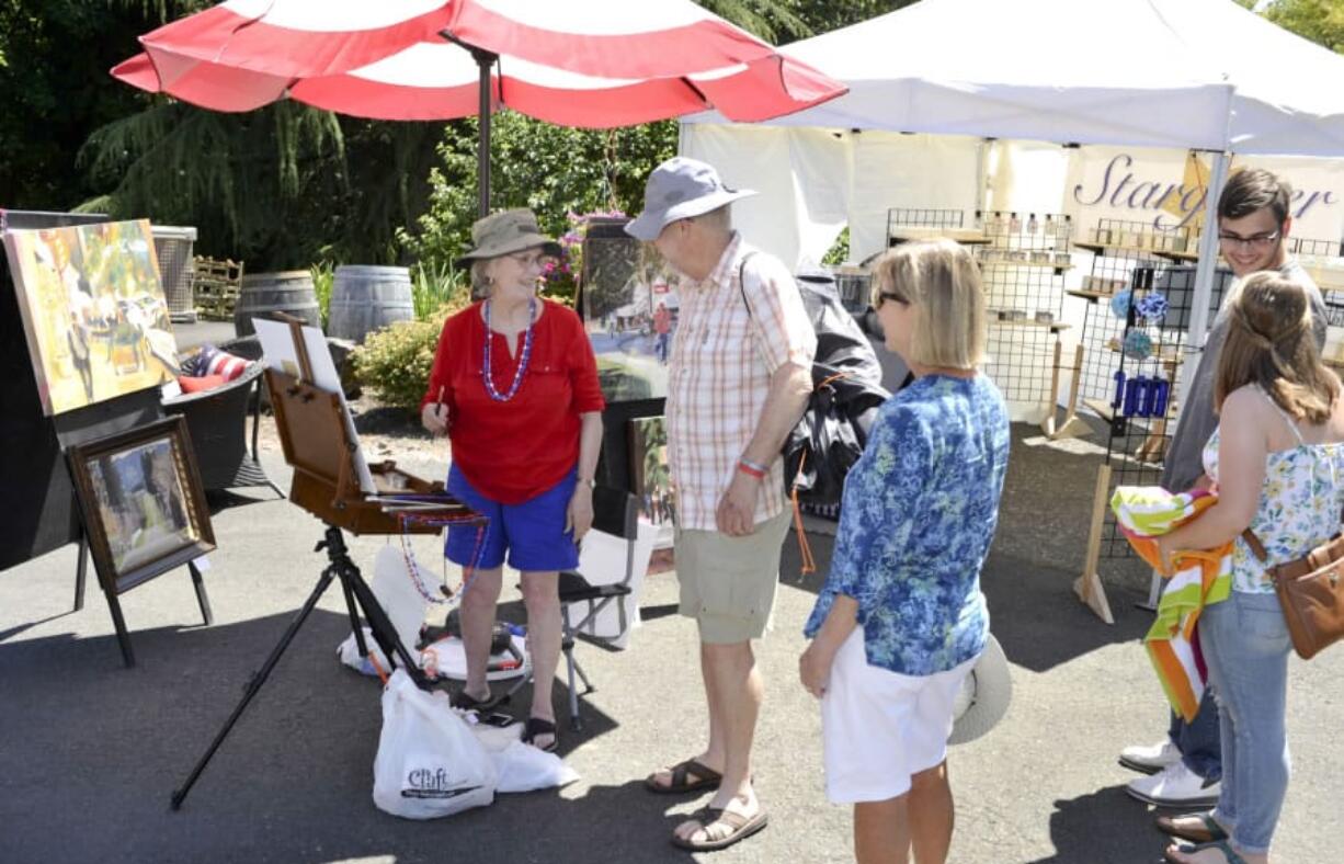 Artist Lila Martin, left, chats with Tom and Judy Barker during the Red Wine, Blues and Art in the Vineyard Festival at Confluence Vineyards and Winery in Ridgefield on Sunday afternoon. The winery has held a wine and blues event, and a separate art show, each July for the past few years and combined them for this year.