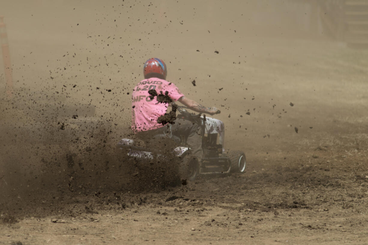 Dirt flies as David Newton rounds the track at the Amboy Territorial Days Celebration’s lawn mower races Sunday. The races have been held in Amboy for 21 years.