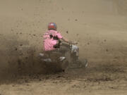 Dirt flies as David Newton rounds the track at the Amboy Territorial Days Celebration’s lawn mower races Sunday. The races have been held in Amboy for 21 years.