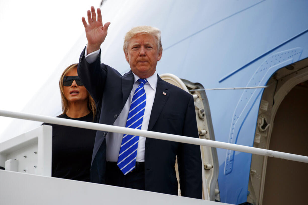 President Donald Trump waves as he boards Air Force One with first lady Melania Trump for a trip to Poland and Germany, Wednesday, July 5, 2017, at Andrews Air Force Base, Md.