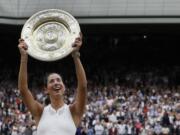 Spain's Garbine Muguruza holds the trophy after defeating Venus Williams of the United States in the Women's Singles final match on day twelve at the Wimbledon Tennis Championships in London Saturday, July 15, 2017.