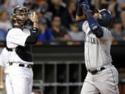 Seattle Mariners' Nelson Cruz, right, celebrates after hitting a two-run home run as Chicago White Sox catcher Kevan Smith looks to the field during the sixth inning of a baseball game Saturday, July 15, 2017, in Chicago. (AP Photo/Nam Y.