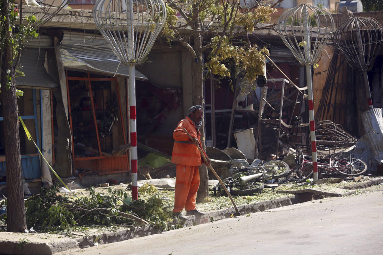 A municipality worker cleans up at the site of a suicide attack in Kabul, Afghanistan, Monday, July 24, 2017. A suicide bomber rammed his car packed with explosives into a bus carrying government employees in the Afghan capital.