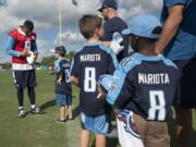 Tennessee Titans quarterback Marcus Mariota (8) signs autographs for kids after the first practice of NFL football training camp, Saturday, July 29, 2017, in Nashville, Tenn.