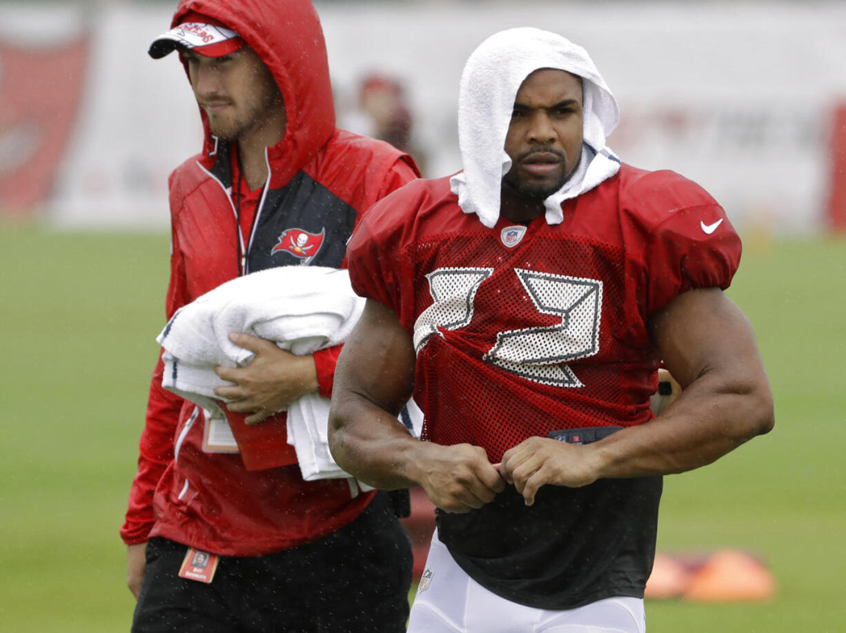 Tampa Bay Buccaneers running back Doug Martin (22) is covered up as rain associated with Tropical Storm Emily falls during an NFL football training camp practice Monday, July 31, 2017, in Tampa, Fla.