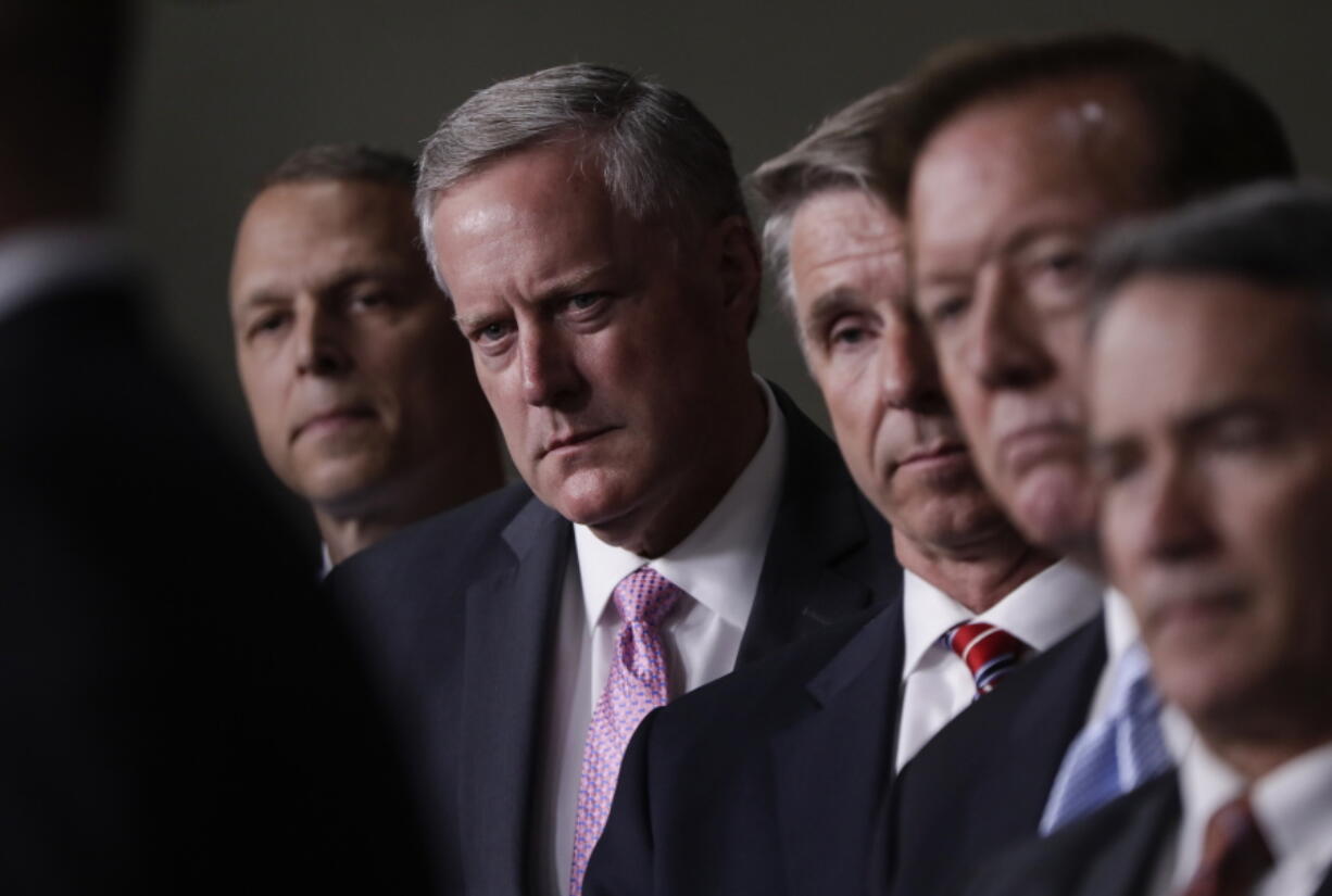 House Freedom Caucus Chairman Rep. Mark Meadows, R-N.C., second from left, and others, participates in a news conference on Capitol Hill in Washington, Wednesday, July 12, 2017, to say that his group wants to delay the traditional August recess until work is accomplished on health care, the debt ceiling and tax reform. (AP Photo/J.