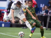 Vancouver Whitecaps defender Jake Nerwinski (28) vies for control of the ball with Portland Timbers midfielder Sebastian Blanco, right, during the first half of MLS soccer game action in Vancouver, British Columbia, Sunday, July, 23, 2017.