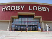 Customers walk to a Hobby Lobby store in Oklahoma City. Federal prosecutors say Hobby Lobby Stores has agreed to pay a $3 million federal fine and forfeit thousands of ancient Iraqi artifacts smuggled from the Middle East that the government alleges were intentionally mislabled. Prosecutors filed a civil complaint in New York on Wednesday in which Oklahoma City-based Hobby Lobby consented to the fine and forfeiture of thousands of tablets and bricks written in cuneiform, one of the earliest systems of writing, as well as other artifacts that prosecutors say were shipped without proper documentation.