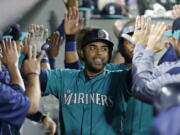 Seattle Mariners' Nelson Cruz is greeted in the dugout after he hit a three-run home run during the eighth inning of the team's baseball game against the Oakland Athletics, Friday, July 7, 2017, in Seattle. (AP Photo/Ted S.