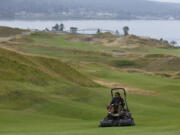 Greenskeeper Slater Heath mows near the 12th green at Chambers Bay. Ted S.