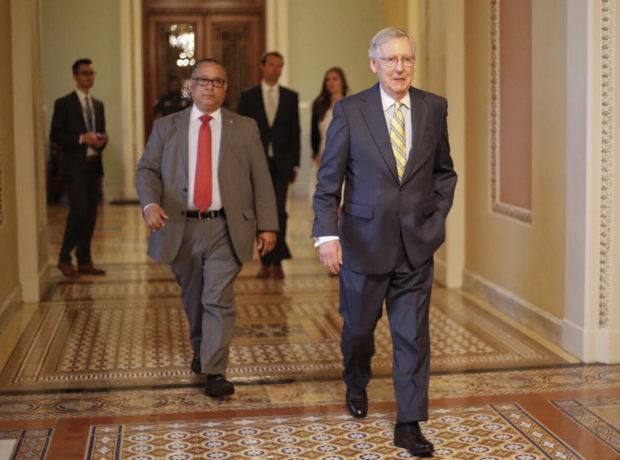 FILE - In this July 13, 2017 file photo, Senate Majority Leader Mitch McConnell of Ky. walks to his office on Capitol Hill in Washington. Republicans’ latest health care plan would create winners and losers among Americans up and down the income ladder, and across age groups.