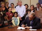 Washington Gov. Jay Inslee signs into law a measure that seeks to bring the state into compliance with a court mandate to increase state dollars to basic education Thursday, July 6, 2017, in Olympia. Washington has been in contempt of court for lack of progress on satisfying a 2012 state Supreme Court ruling that found that school funding was not adequate.