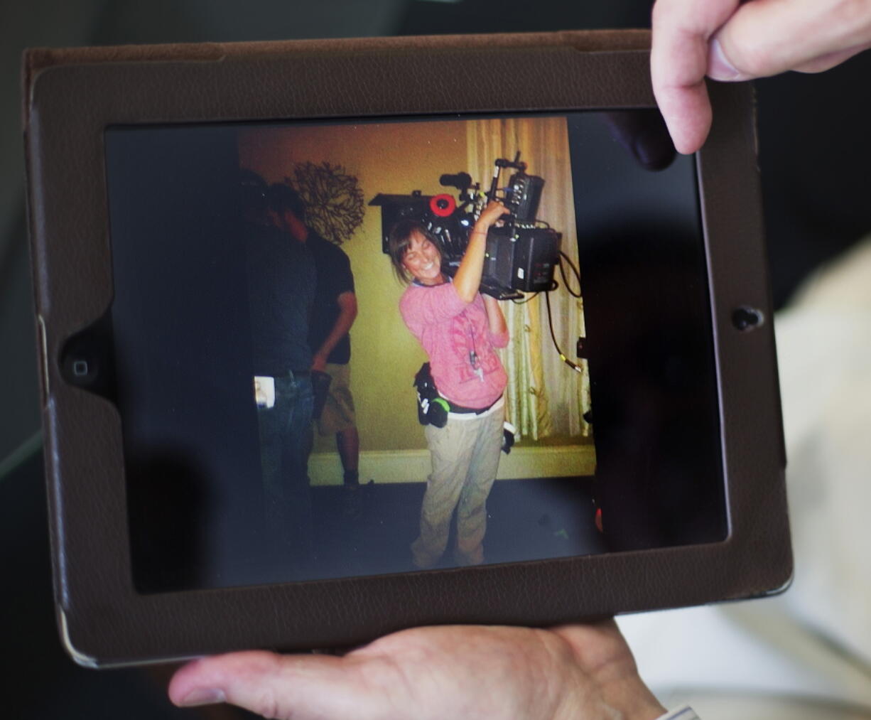 In this photo taken April 9, 2014 Elizabeth and Richard Jones, flip through photos of their daughter Sarah Jones, the 27-year-old camera assistant killed by a freight train while filming a movie in southeast Georgia, as they sit in their attorney’s office, in Atlanta. After a freight train ran over Sarah Jones as she worked with a crew shooting a movie scene on a Georgia railroad bridge, the film’s director spent a year in jail for the 27-year-old camera assistant’s death.