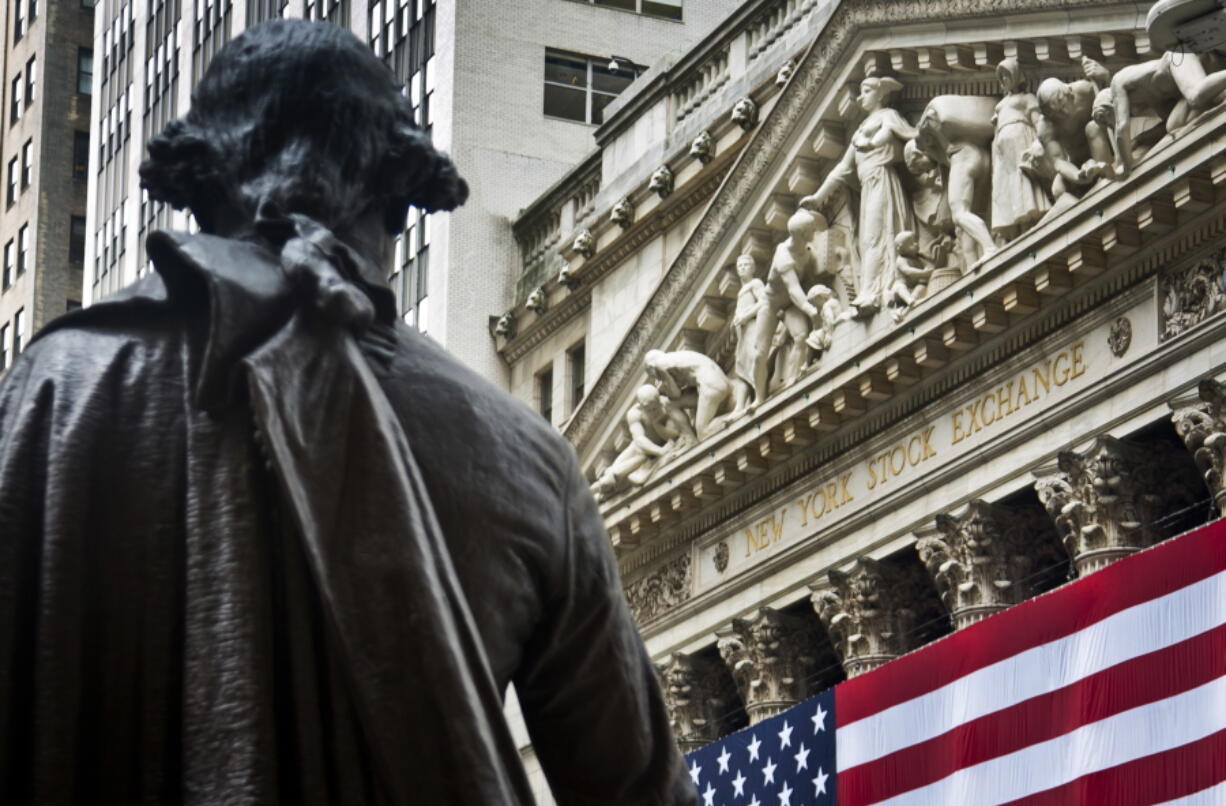 FILE - In this Wednesday, July 8, 2015, file photo, a statue of George Washington stands at Federal Hall near the flag-covered pillars of the New York Stock Exchange, in New York. Global shares are mostly higher in Europe, Wednesday, July 5, 2017, after Asia reversed early losses spurred by concern over North Korea’s launch of a long-range missile on Tuesday. Trading was subdued after the U.S. Independence Day holiday and ahead of the summit of the Group of 20 industrial nations later in the week.