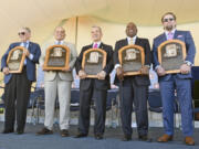 Newly-inducted National Baseball Hall of Famers from left, Bud Selig, Ivan Rodriguez, John Schuer, Tim Raines Sr., and Jeff Bagwell hold their plaques after an induction ceremony at the Clark Sports Center on Sunday, July 30, 2017, in Cooperstown, N.Y.