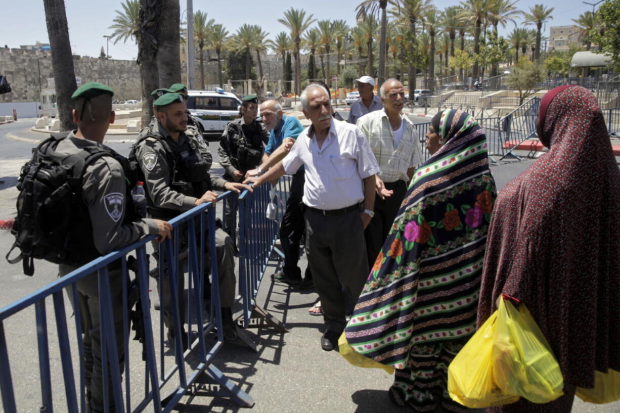 Israeli border police officers stop people from entering the Damascus Gate in Jerusalem’s Old City, Saturda. On Friday, three Palestinian assailants opened fire from a sacred site known to Muslims as the Noble Sanctuary and to Jews as the Temple Mount, inside the walled Old City, killing two Israeli police officers before being shot dead.