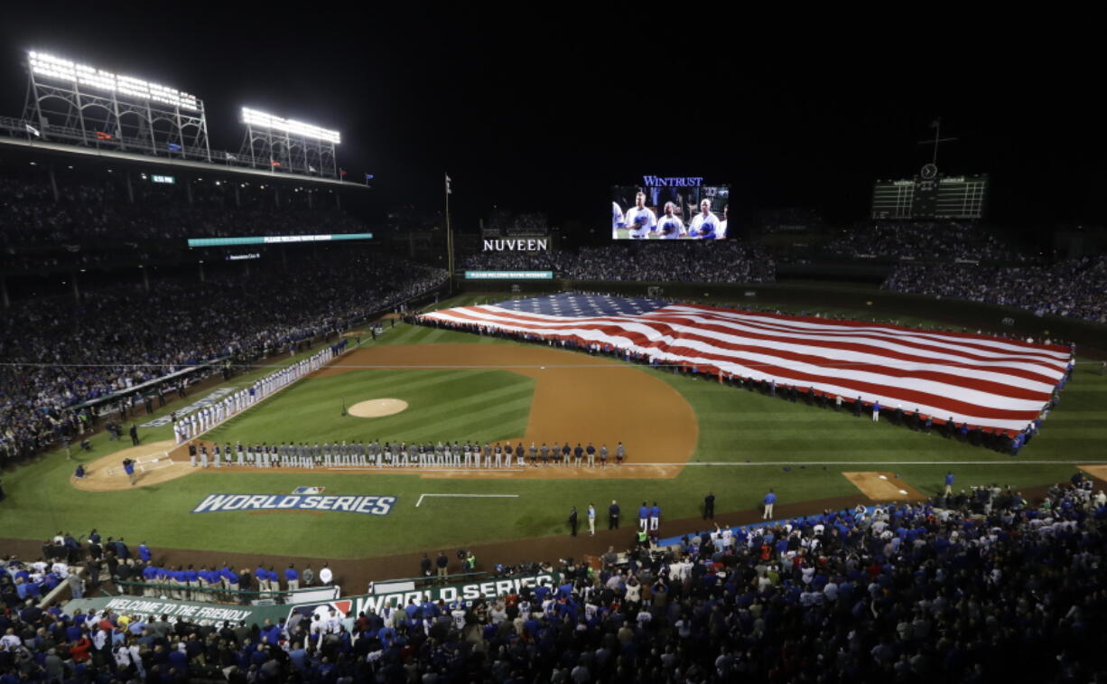 A giant United States flag is displayed during the national anthem before Game 3 of the Major League Baseball World Series between the Cleveland Indians and the Chicago Cubs in Chicago. The anthem has been a standard part of U.S. sports games since World War II. Experts say Game 1 of the 1918 World Series between the Boston Red Sox and the Chicago Cubs helped pave the way. The song became the official national anthem in 1931.